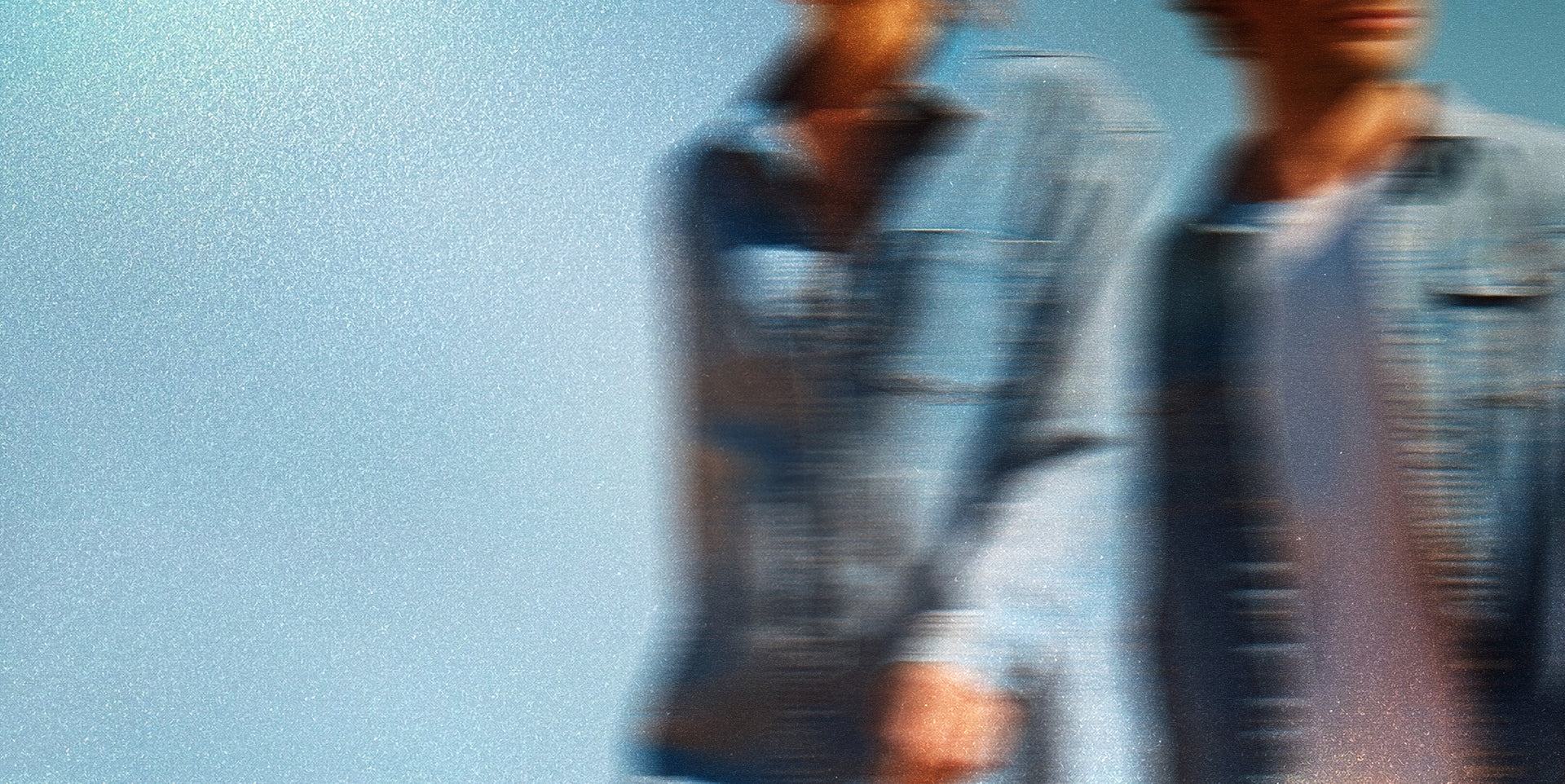 Two people wearing DUER denim shirts and Jeans against a clear blue sky.